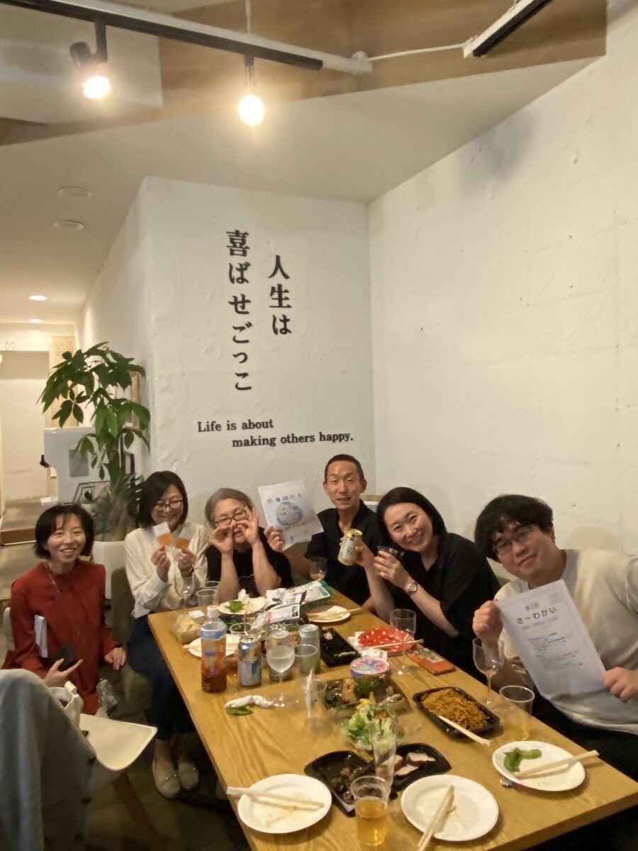 親睦会。テーブルを囲むメンバーの集合写真